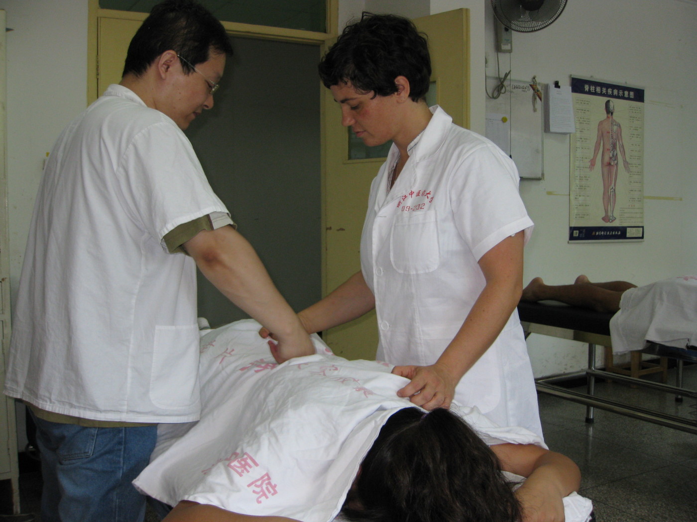 Jennifer doing Tuina massage on a patient with a teacher